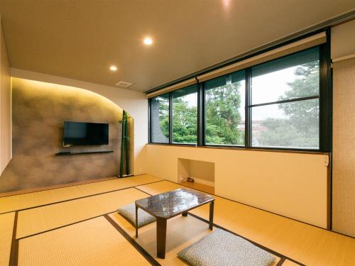 a living room with a table and a tv at House Hotel Kenrokuzaka in Kanazawa