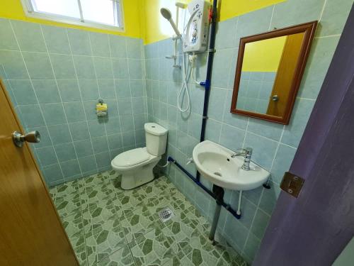 bagno con servizi igienici, lavandino e specchio di THE CLOUD KINABALU- Chalet a Ranau