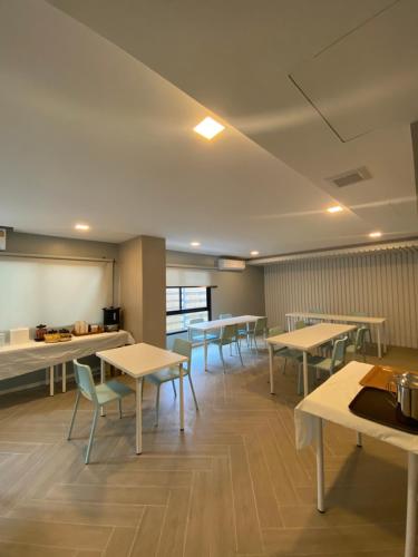 a cafeteria with tables and chairs and a whiteboard at Napa Hotel Ratchaburi in Ratchaburi