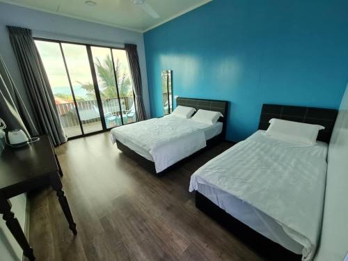 um quarto com 2 camas e uma parede azul em THE CLOUD KINABALU- Chalet em Ranau