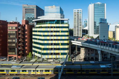 a train in the middle of a city with buildings at toggle hotel suidobashi TOKYO in Tokyo