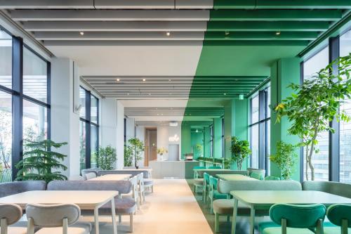 东京toggle hotel suidobashi TOKYO的一间设有桌椅和植物的等候室