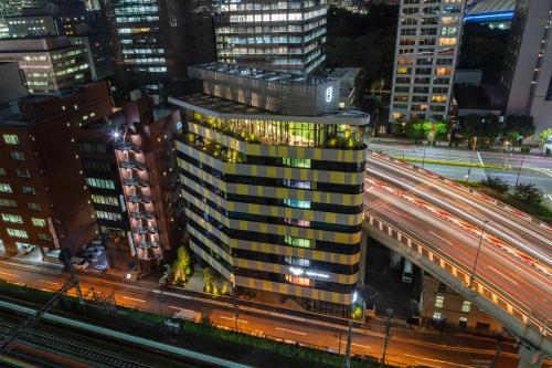 a tall building in a city at night with traffic at toggle hotel suidobashi TOKYO in Tokyo
