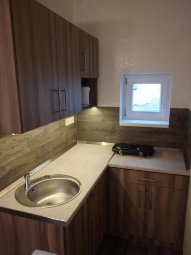 a bathroom with a sink and a tv on the counter at Bem Downtown Apartment in Debrecen