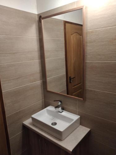 a bathroom with a sink and a mirror at Bem Downtown Apartment in Debrecen