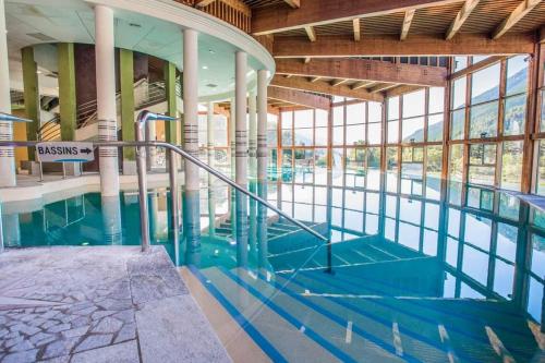 - une piscine avec un panneau dans un bâtiment dans l'établissement Charmant T2 proche Serre Chevalier Vallée 4 personnes, à Briançon