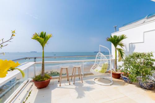 a balcony with palm trees and a view of the ocean at Homestay coco in Vung Tau