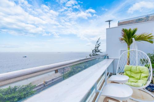 a balcony with two chairs and a view of the ocean at Homestay coco in Vung Tau