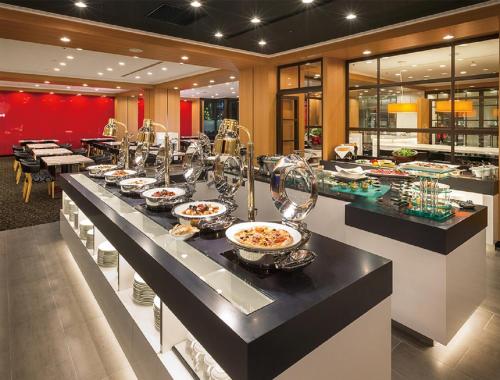 a buffet line with bowls and plates of food at Hotel Associa Toyohashi in Toyohashi
