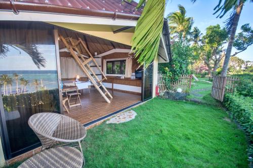 a house with a patio and a lawn with chairs at Ralph's Place in Boracay
