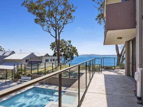 a view of the ocean from the balcony of a house at The Poplars, 2,36 Magnus Street - Comfortable Unit With Air Conditioning and Wi-Fi in Nelson Bay