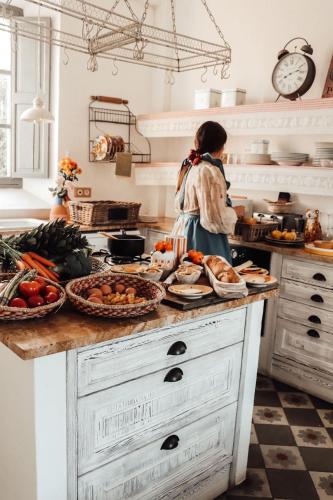 a woman standing in a kitchen with food on a counter at Villa Station by Cassai in Ses Salines