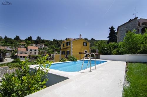 a swimming pool in the backyard of a house at Villa Green Garden in Splitska