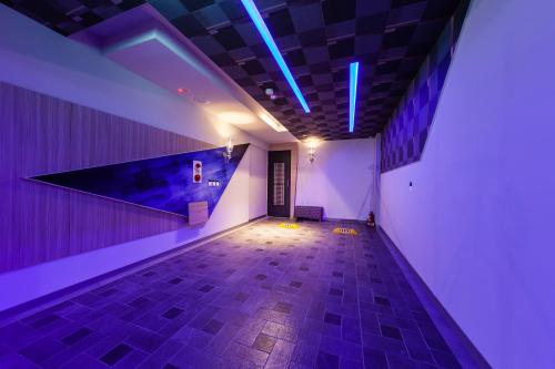a room with a hallway with blue lights on the ceiling at TY Motel in Dayuan