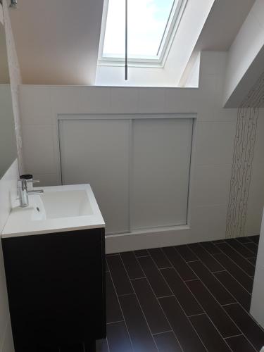 a bathroom with a sink and a skylight at Maison de campagne 6 personnes - "BIZYFAMILY" in Villermain