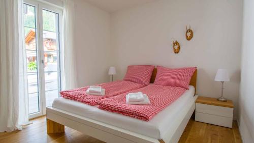 a bedroom with a bed with red pillows and a window at Ferienwohnung im Chalet Alpenrose in Adelboden