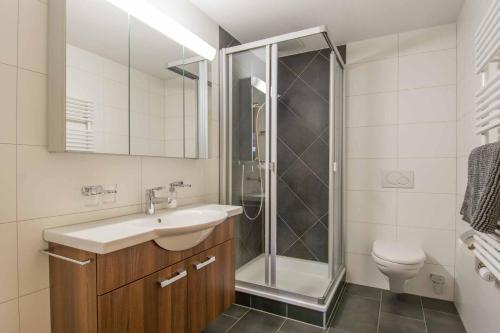a bathroom with a shower and a sink and a toilet at Schützenrain 1. Stock in Adelboden