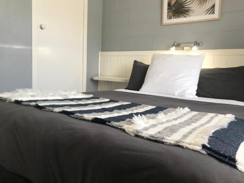 
a bed with white sheets and pillows in a room at Esperance Central Accommodation in Esperance
