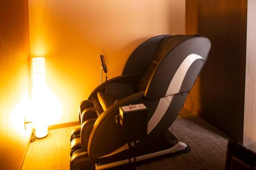 a room with a chair in a hotel room at Dormy Inn Premium Nagasaki Ekimae in Nagasaki