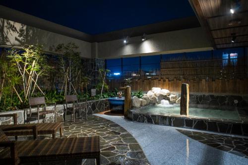 a lobby with a water fountain in the middle at Dormy Inn Premium Nagasaki Ekimae in Nagasaki