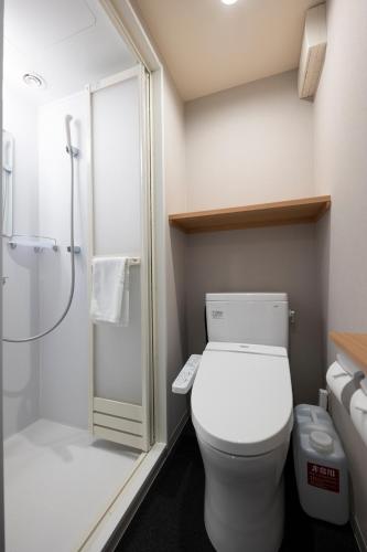 a bathroom with a white toilet and a shower at Dormy Inn Premium Nagasaki Ekimae in Nagasaki
