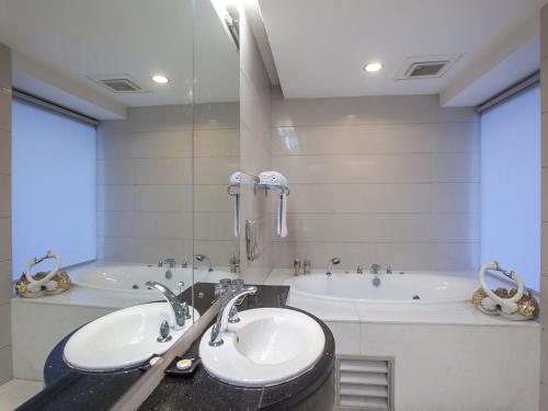 a bathroom with two sinks and a tub at Hua Shi Hotel in Guangzhou