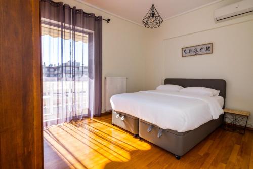 a bedroom with a bed and a large window at Two Bedroom Apartment in Chalandri with Balcony in Athens