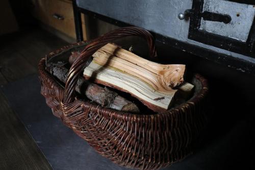 a wicker basket with a piece of wood in it at Almhütte Oberschaller bei Alfenalm - Ferienwohnungen am Berg in Innervillgraten