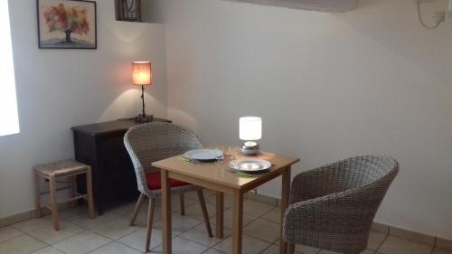 a small table with two chairs and a lamp on it at Le Petit Séguret in Le Puy en Velay