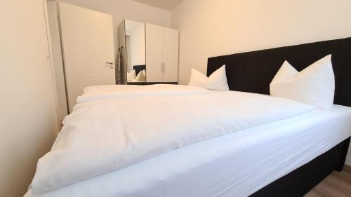 a large white bed with white sheets and pillows at City Apartment Alici in Füssen