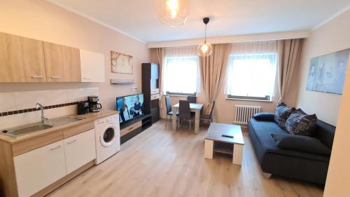a living room with a couch and a tv and a kitchen at City Apartment Alici in Füssen
