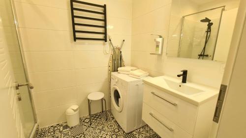 a white bathroom with a sink and a washing machine at City Apartment Alici in Füssen