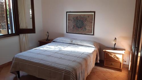 a bedroom with a bed and a picture on the wall at Casa vacanza da rosa in Marsala