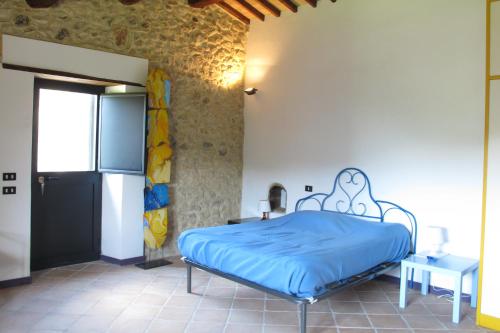 ein Schlafzimmer mit einem Bett mit einer blauen Bettdecke in der Unterkunft Luxury Casale Sabina Valley in Rocca Sinibalda