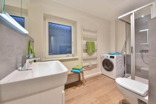Un baño con lavabo y lavadora. en Ferienhaus Wiesenblick, en Ahlbeck