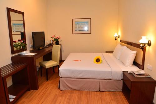 una camera d'albergo con letto, scrivania e computer di Cheng Ho Hotel a Malacca