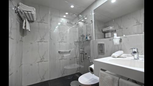 a bathroom with a shower and a toilet and a sink at Hotel De Ville in Beirut