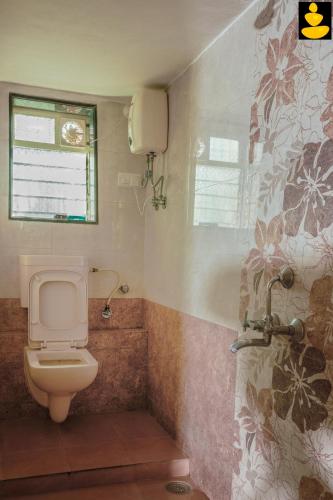 a bathroom with a toilet and a shower at LivingStone 3BHK Beach House Alibaug in Alibaug