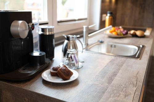 a counter top with a plate of brownies and a coffee maker at LandAroma in Bestensee