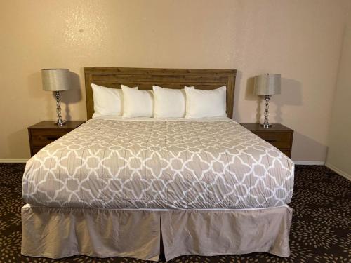 a bed in a hotel room with two lamps at Eagle Hotel in Palmer
