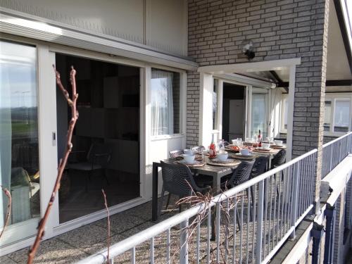 a balcony with a table with food on it at Familie-Beachvilla Ooster-schel-de in Kamperland