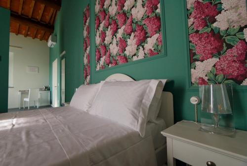 a bedroom with a bed with flowers on the wall at Podere La Doccia in Civitella in Val di Chiana