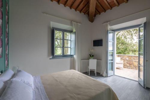 sypialnia z łóżkiem i przesuwanymi drzwiami szklanymi w obiekcie Podere La Doccia w mieście Civitella in Val di Chiana