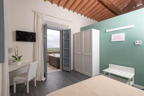 a bedroom with a bed and a desk and a bathroom at Podere La Doccia in Civitella in Val di Chiana