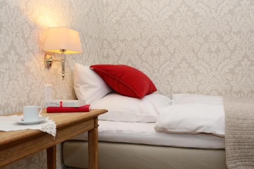 a bed with a red pillow on top of it at Hotel No. 11 in Lüdinghausen