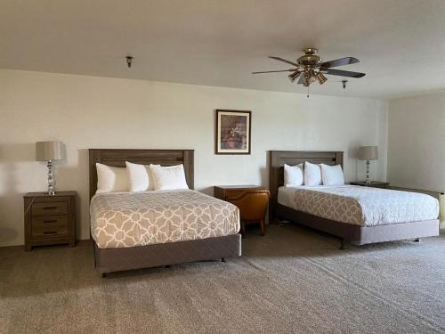 a hotel room with two beds and a ceiling fan at Eagle Hotel in Palmer