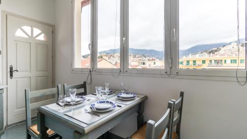 a dining room table with a view of a city at Italianway - Roma 70 in Sanremo