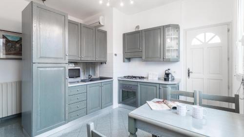 a kitchen with blue cabinets and a table in it at Italianway - Roma 70 in Sanremo