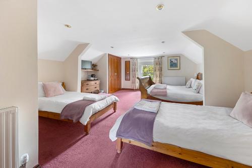 a bedroom with three beds in a room at Haselbury Mill in Crewkerne