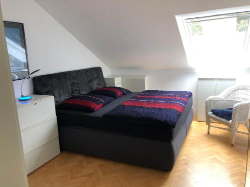 ein Schlafzimmer mit einem schwarzen Bett mit zwei roten Kissen in der Unterkunft Casa Vesalia in Wesel